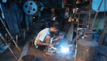 A worker welding an iron plate at an iron utensils manufacturing unit in Kolkata (Rupak de Chowdhuri/NurPhoto/Shutterstock)

