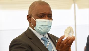 President Mokgweetsi Masisi looks at a 1,000-carat uncut diamond discovered in the country's Jwaneng mine on June 16, 2021 (Shutterstock)