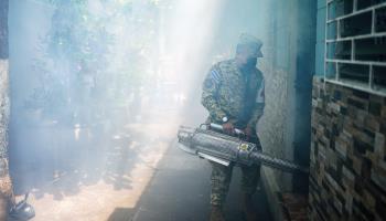 A soldier fumigates homes in an effort to combat dengue. El Salvador, July 2024 (Camilo Freedman/SOPA Images/Shutterstock)