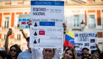 Protesters with a placard showing the opposition-reported unofficial vote tally (Luis Soto/SOPA Images/Shutterstock)