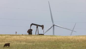 An oil well and wind turbines seen on the Osage Nation Reservation, Oklahoma, August 12, 2024 (Jim West/imageBROKER/Shutterstock)