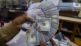 A currency dealer in Karachi holding US dollars (Shahzaib Akber/EPA-EFE/Shutterstock)

