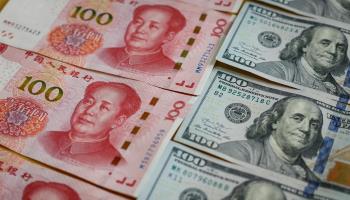 Chinese 100 renminbi notes next to US 100 dollar notes (MARK R CRISTINO/EPA-EFE/Shutterstock)