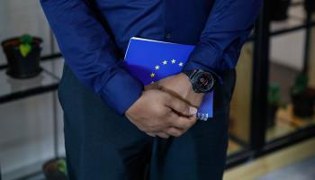 An officer holding a book containing EU regulatory proposals on deforestation (Fazry Ismail/EPA-EFE/Shutterstock)