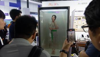 Visitors interacting with a digital human at a trade show in China, July 2024 (Ying Tang/NurPhoto/Shutterstock)