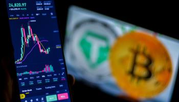 The Bitcoin logo and the Tether USDT logo are displayed on a screen near a trading board (Hasan Mrad/IMAGESLIVE via ZUMA Press Wire/Shutterstock)