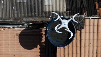 A drone dropping larvicide in a water tank in Belo Horizonte, Brazil (Douglas Magno/Getty Images)