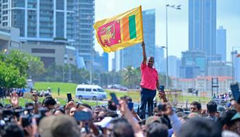 A supporter of President Anura Kumara Dissanayake waving the national flag near the Presidential Secretariat following Dissanayake’s swearing-in ceremony on September 23 (Ishara S Kodikara/AFP/Getty Images)

