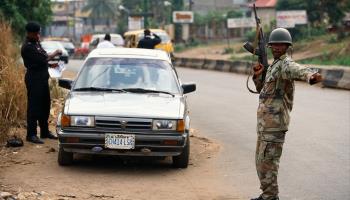 A Nigerian soldier stands by while a police officer searches a vehicle (James Marshall/The Image Bank Unreleased/Getty Images)