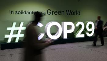 Attendees walk past the COP29 logo in Baku (STRINGER/AFP/Getty Images)