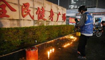 A man standing near candles left outside the Zhuhai Sports Centre a day after a car attack killed dozens there (Michael Zhang/AFP/Getty Images)

