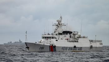 A China Coast Guard ship, with a Chinese naval vessel in the background, in the South China Sea (Jam Sta Rosa/AFP/Getty Images)