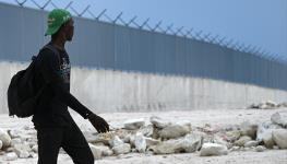 A Haitian man walks past a section of wall being built at the Dominican Republic-Haiti border. Pedernales, Dominican Republic (Federico Parra/AFP/Getty Images)