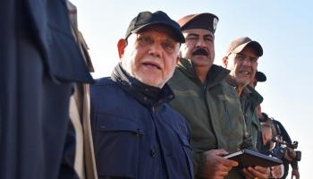 The head of the Badr faction, member of Iraq's Popular Mobilisation Forces, Hadi al-Amiri stands among Iraqi army officers as they tour the Iraq-Syrian border, December, 2024 (Zaid Al-Obeidi/AFP via Getty Images)